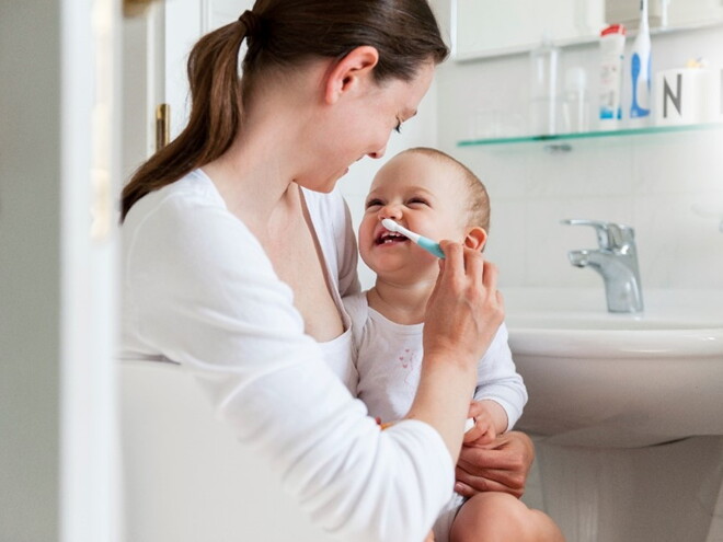 A mother taking care of her children’s dental care