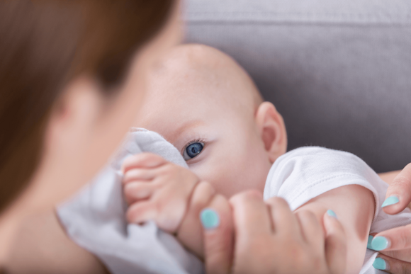 A baby enjoying the benefits of breastfeeding while eating.