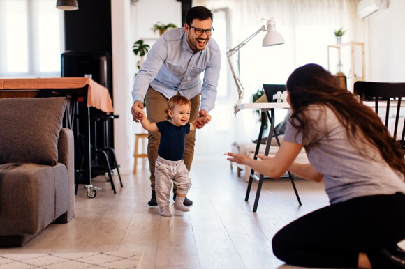 Parents celebrating their baby’s first steps.