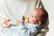 A woman feeding her child with the milk se extracted from her breast pump.