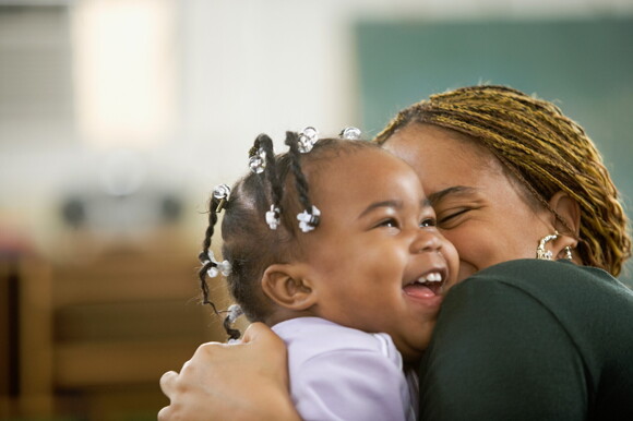 A mother hugging her toddler after teething.